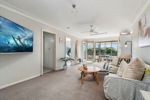 Relax in this stylish living area with a large flat-screen TV, dining table, and comfortable seating.