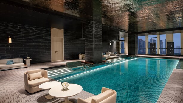 Una piscina interior moderna con vistas al horizonte de la ciudad.