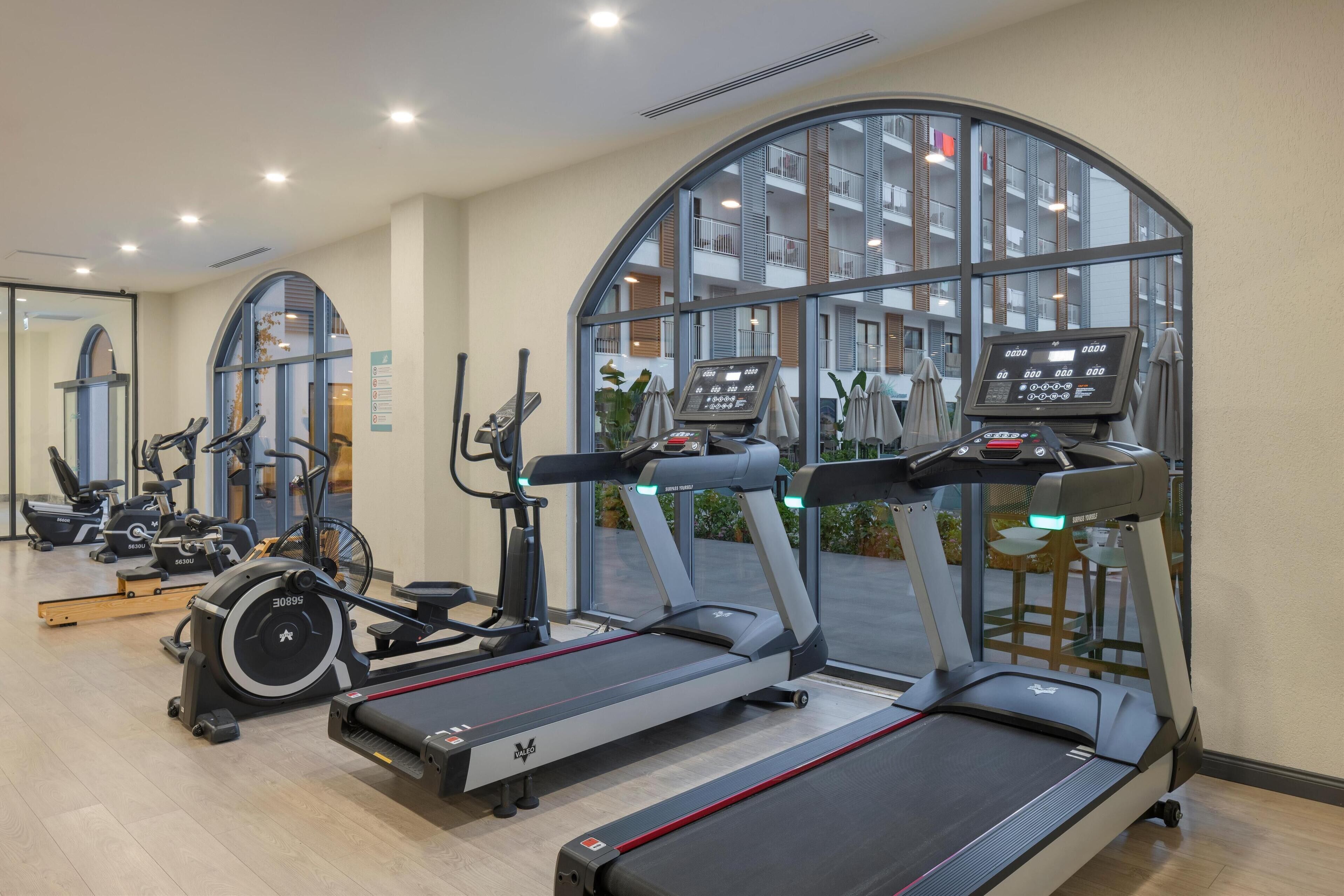A gym with treadmills, stationary bikes, and elliptical machines.