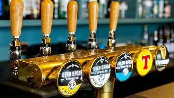 A bar with multiple taps, each labeled with different beer brands.