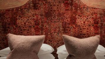 A bed with two pillows and a headboard with a floral pattern.