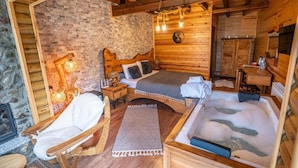 A cozy wooden cabin room with a bed, a chair, a small table, and a bathtub. - Abant Pelit  (Bolu)