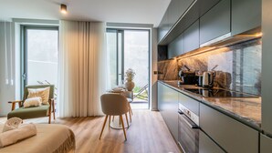 Een moderne keuken met een strak aanrecht, roestvrijstalen apparatuur en uitzicht op het buitengebied.