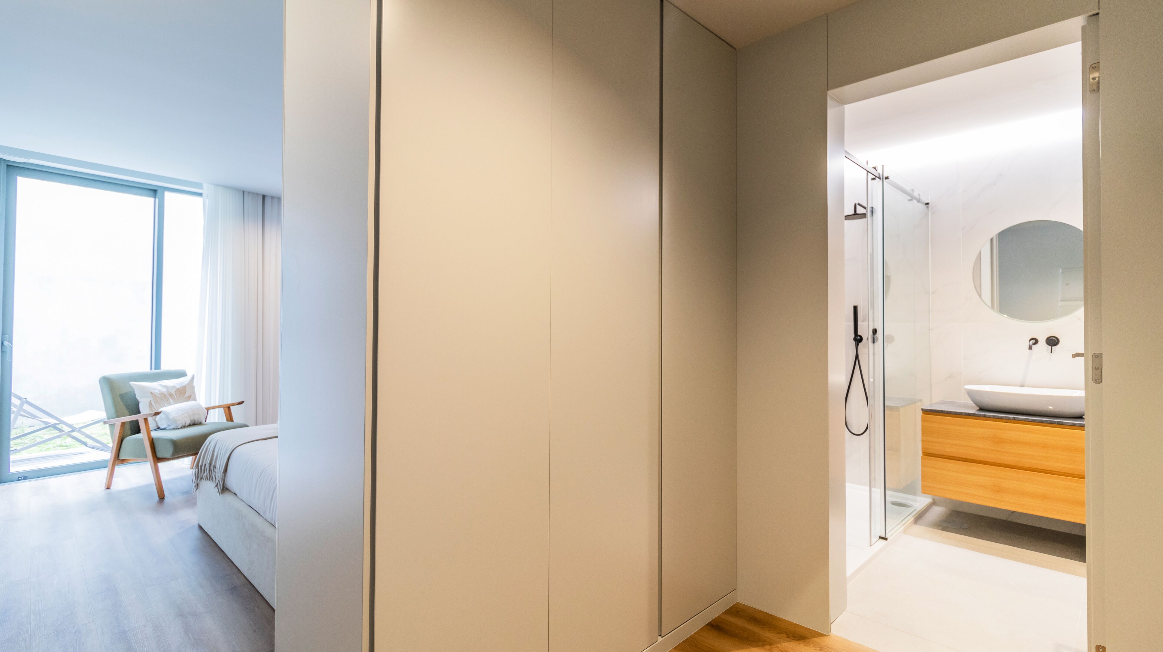 Une chambre moderne avec une grande fenêtre, un lit et une chaise.