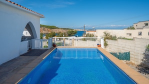 A rectangular swimming pool with clear blue water, surrounded by a white wall and a small white building with an arched doorway. - Sharon: Semi-detached house with sea views and private pool (L'Escala)