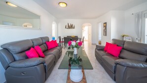 A living room with two leather sofas, a glass coffee table, and a vase with flowers. - Sharon: Semi-detached house with sea views and private pool (L'Escala)