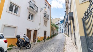 A narrow cobblestone street flanked by buildings with balconies and a sign reading "BECO DA BOMBARDOS". - Bombarda 32 (Lisbon)
