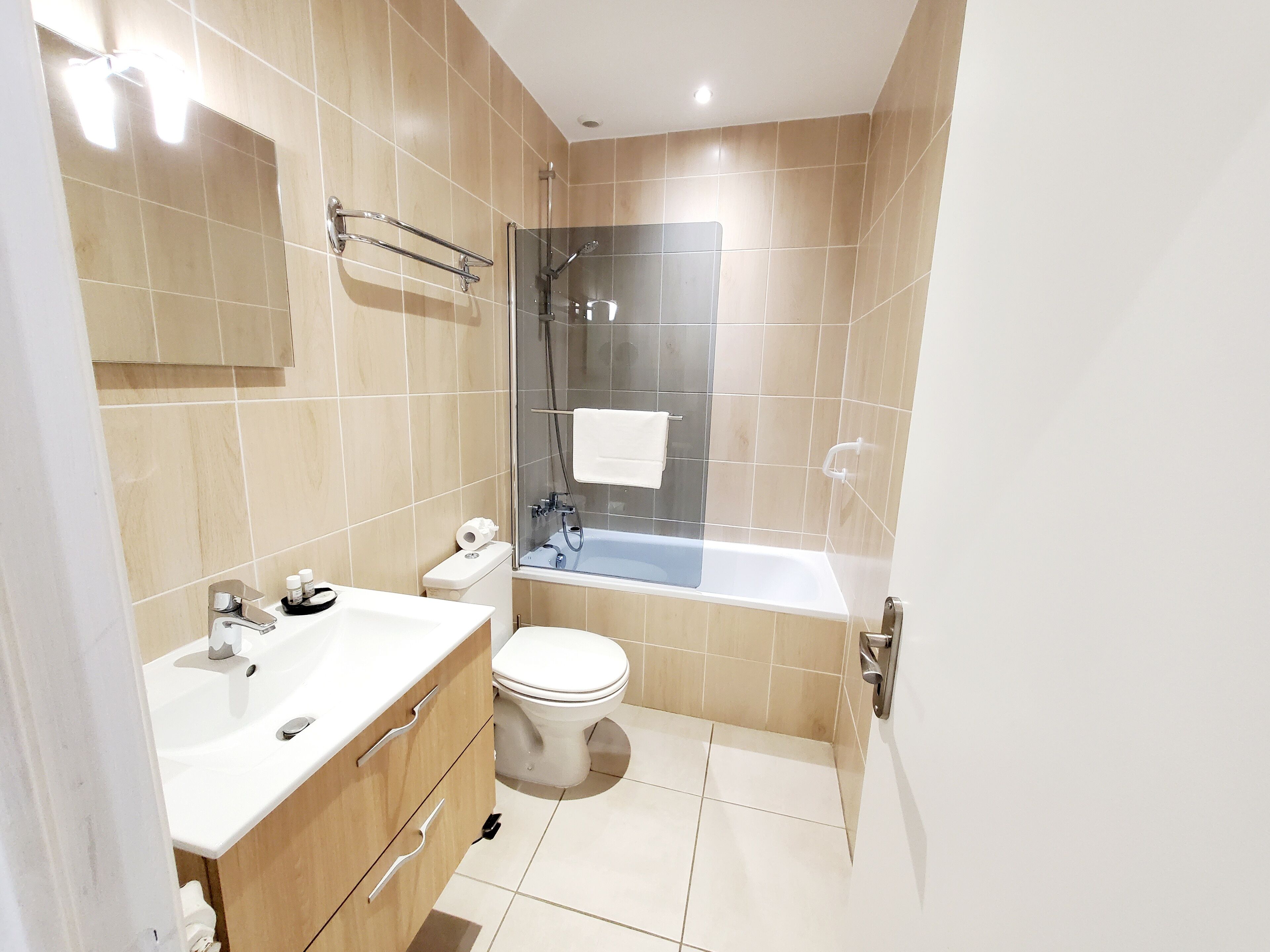 A modern bathroom with a sink, toilet, and glass-enclosed shower.
