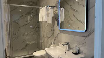 Quarto triplo conforto, várias camas | Banheiro | Chuveiro, produtos de toalete grátis, toalhas de banho, papel higiênico