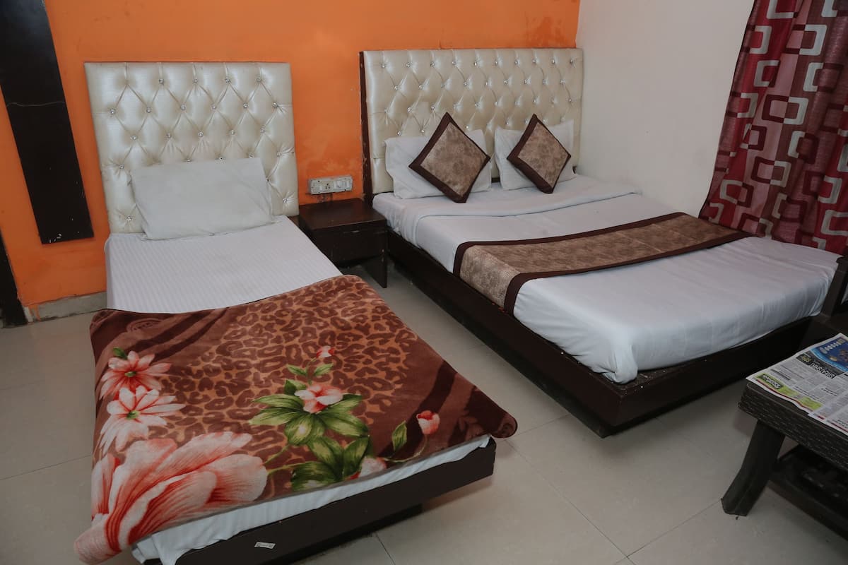 Quarto de hotel com duas camas, cada uma com um design de cabeceira diferente.