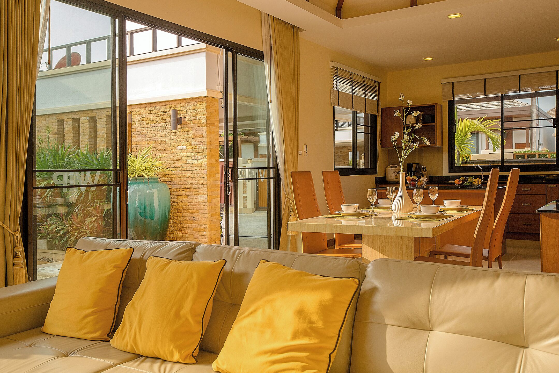 A modern living room with a sofa, dining table, and chairs.