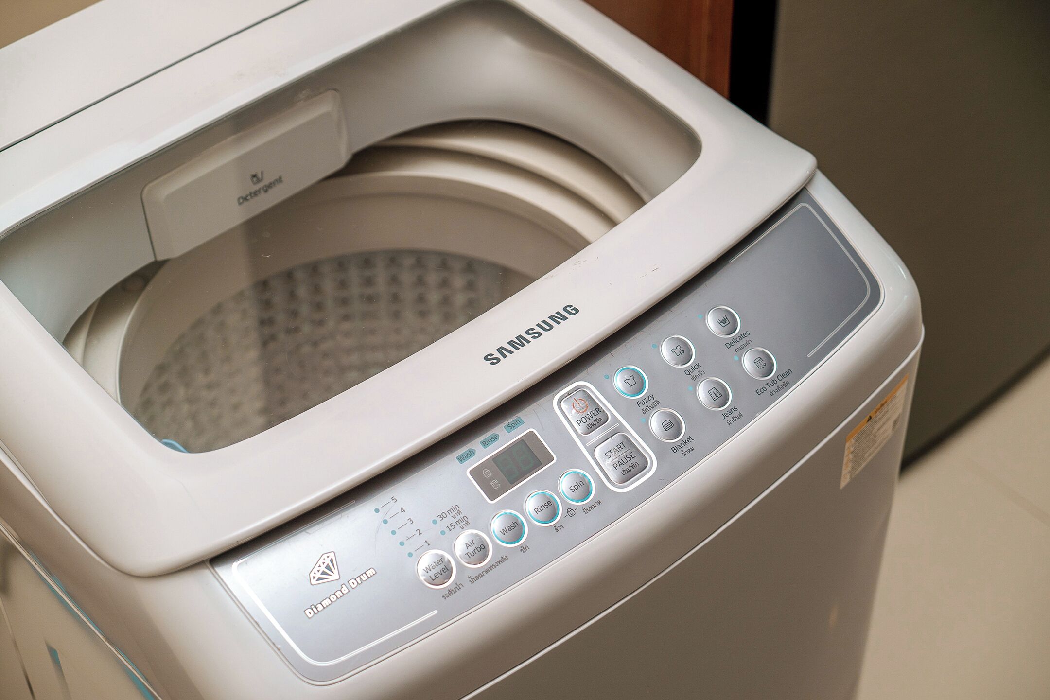 A Samsung washing machine with a control panel featuring multiple buttons and a digital display.