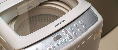 A Samsung washing machine with a transparent door, control panel, and a detergent compartment.