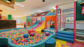 A children's play area with a ball pit, slides, and soft play structures.