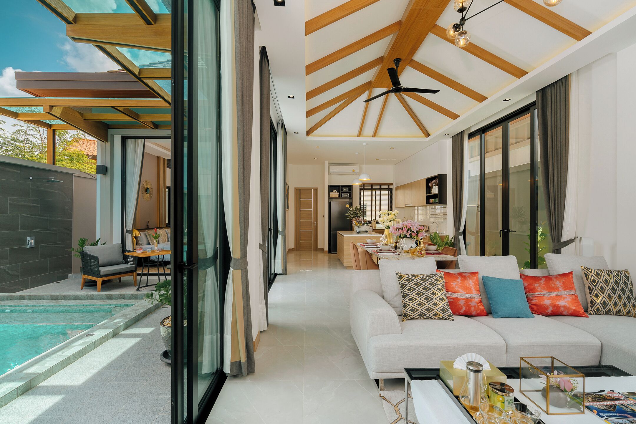 A modern living room with a sofa, coffee table, and a pool area.