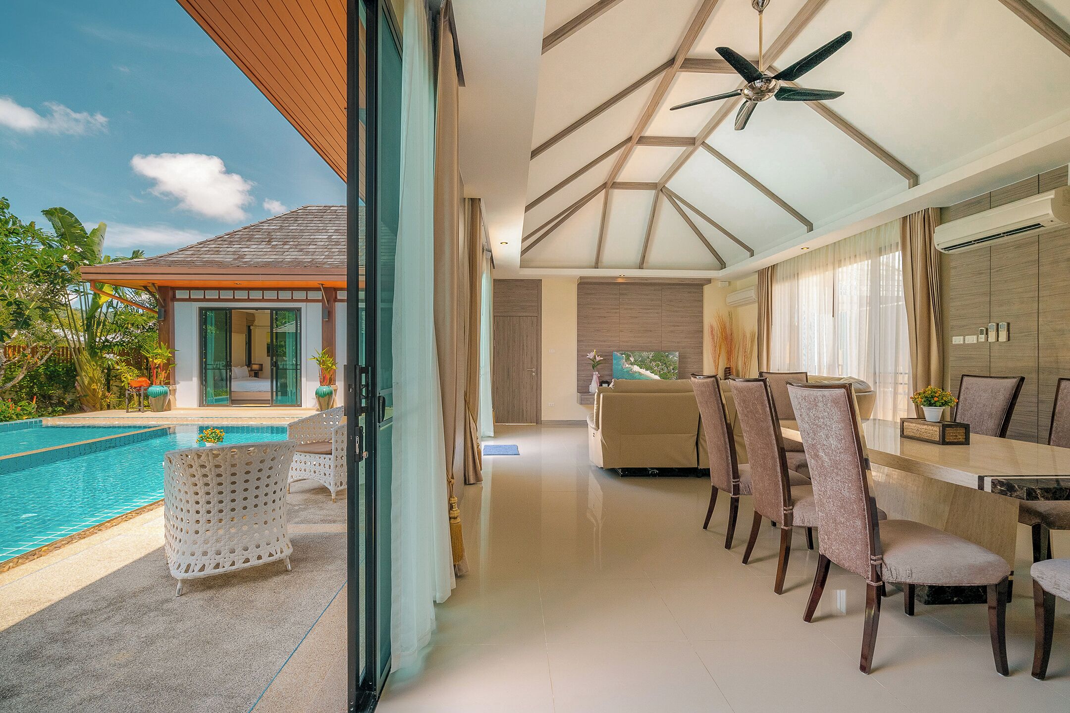 A modern interior with a pool, dining area, and a ceiling fan.