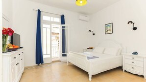 A bedroom with a bed, bedside tables, a TV, and a window with curtains. - RM4 Chambre en étage - Côté Ville (Sliema)