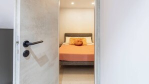A bedroom with a bed, a door with a handle, and a light switch. - FL2 Sliema Cozy 1BR Getaway with Balcony (Sliema)