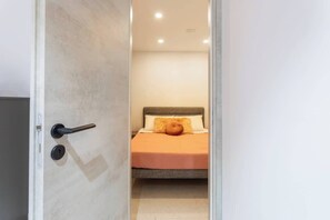 Une chambre à coucher avec un lit, une porte dotée d’une poignée et un interrupteur.