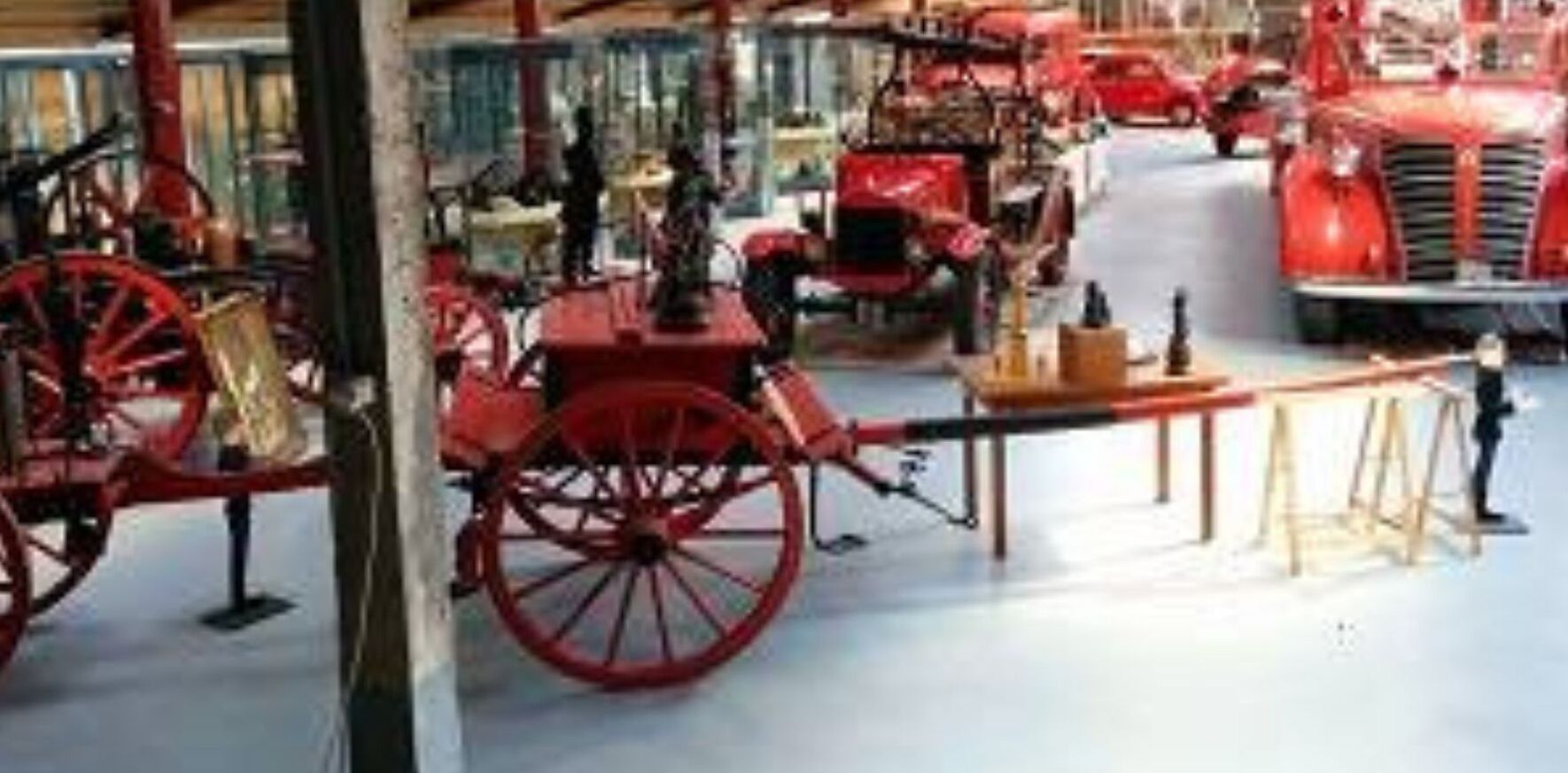 A museum exhibit with vintage vehicles and displays.