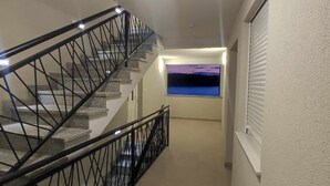 A staircase with a metal railing leading to a landing.