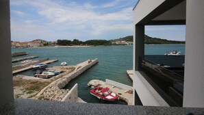 A marina with boats docked, a clear sky, and a view of the coastline.