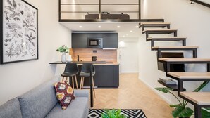 Un appartement moderne avec une chambre en mezzanine, une cuisine et un coin repas.
