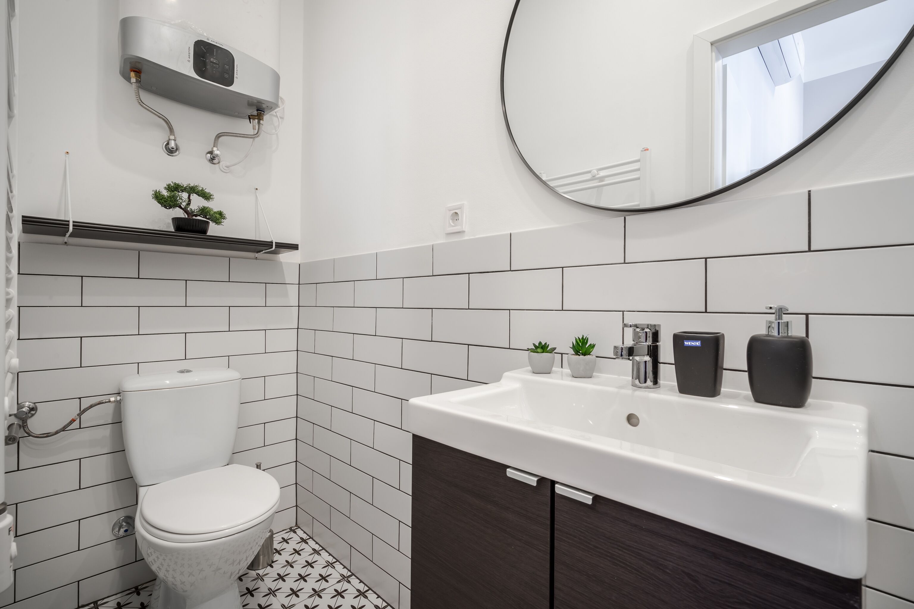 A modern bathroom with a toilet, sink, and mirror.