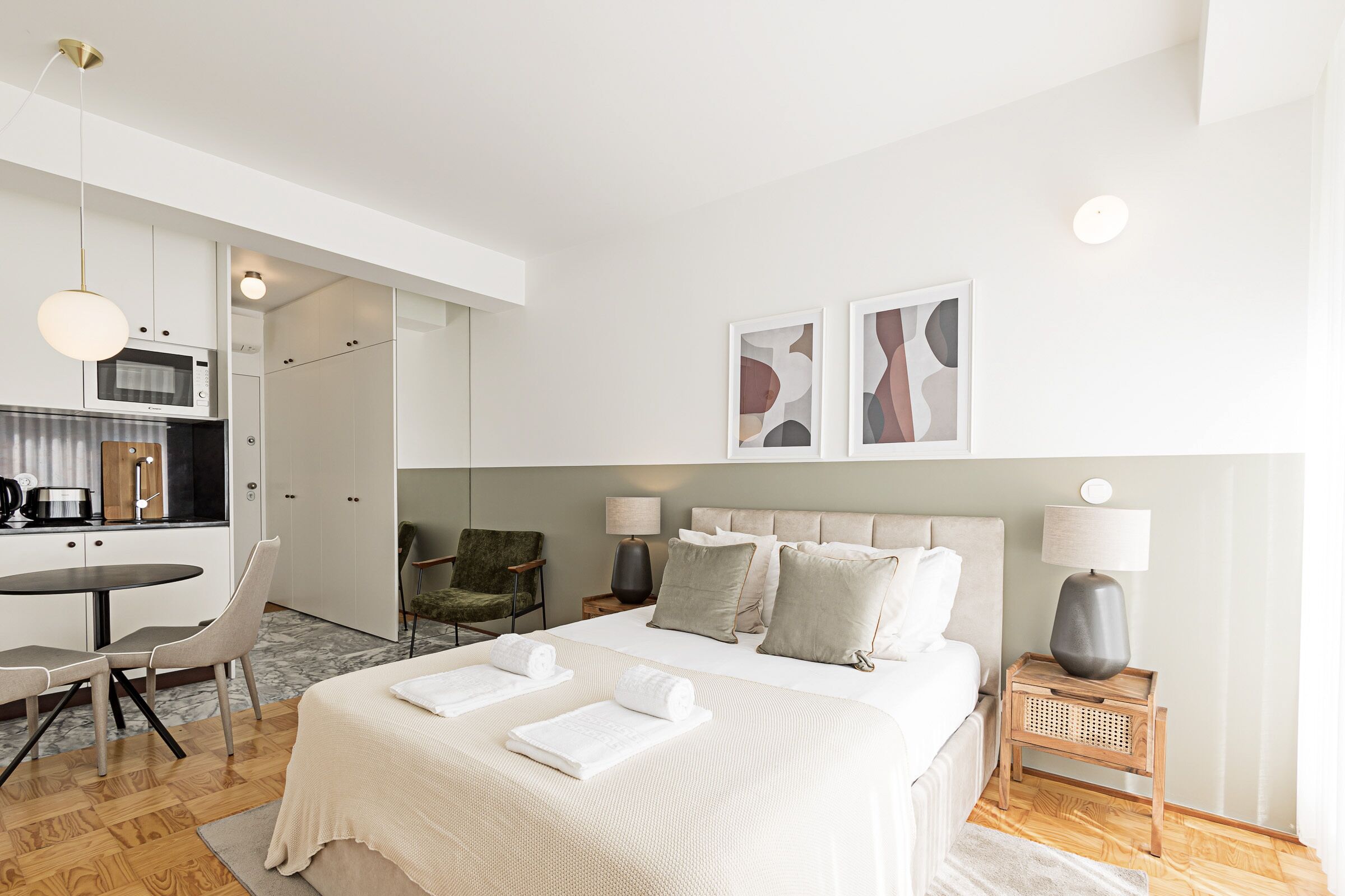 Une chambre d’hôtel moderne équipée d’un lit, de tables de chevet, d’un bureau et d’une chaise.