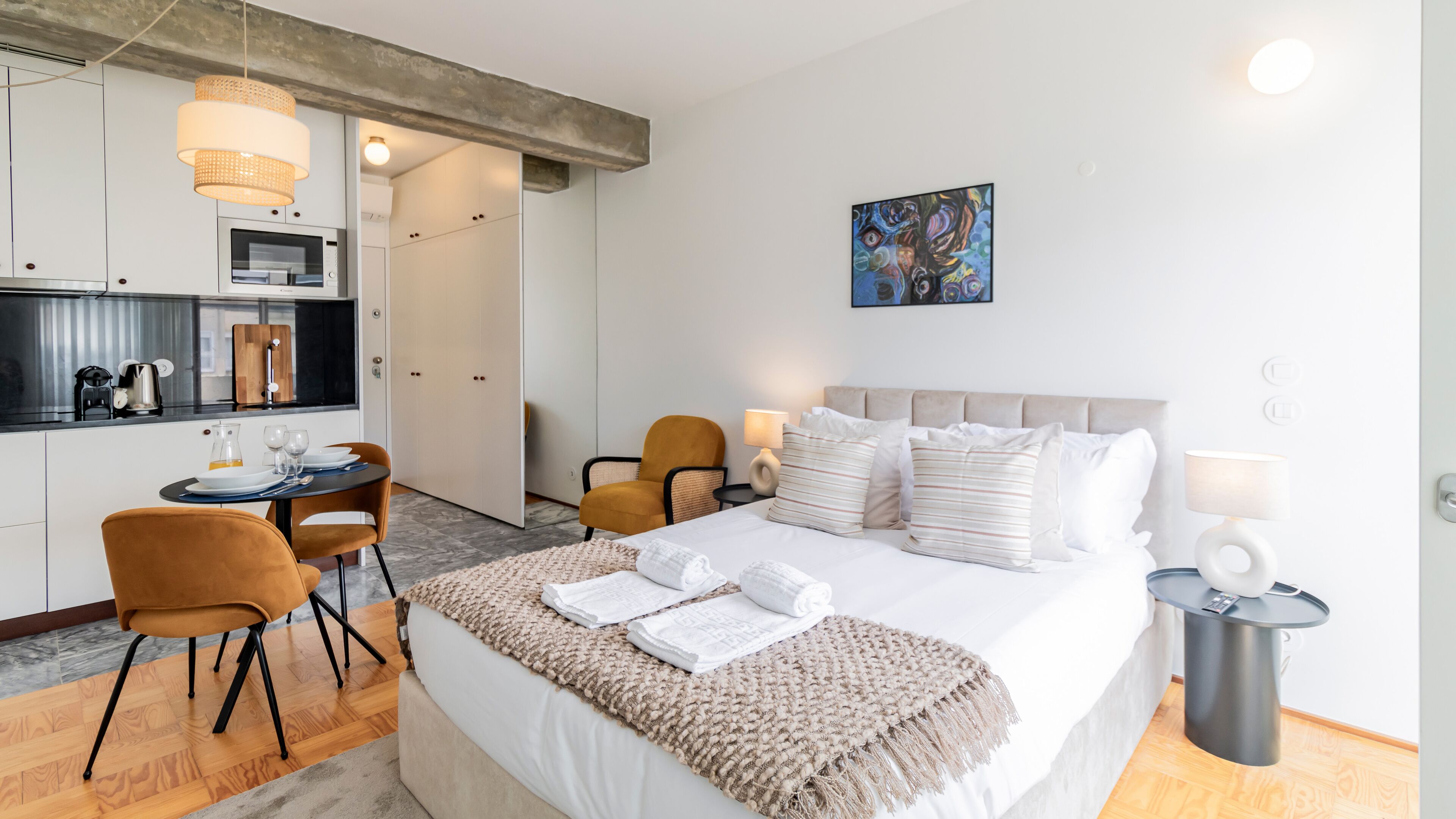 Une chambre d’hôtel moderne équipée d’un lit, d’un coin repas et d’une kitchenette.