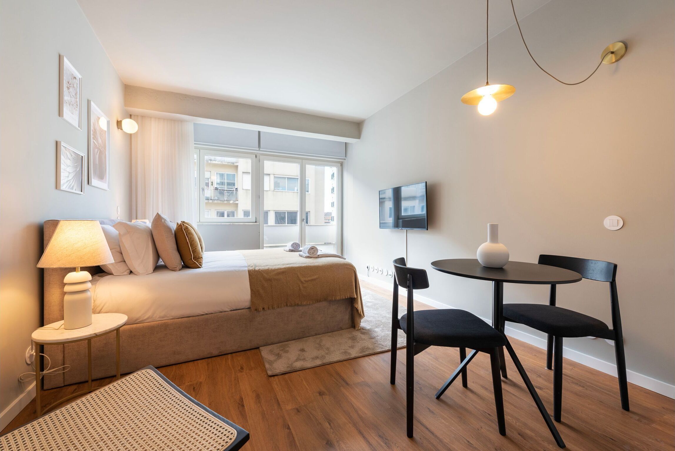 Ein modernes Schlafzimmer mit Bett, Nachttischlampe und Fernseher.