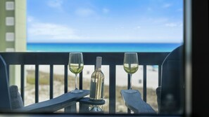 A balcony with a view of the beach and ocean.