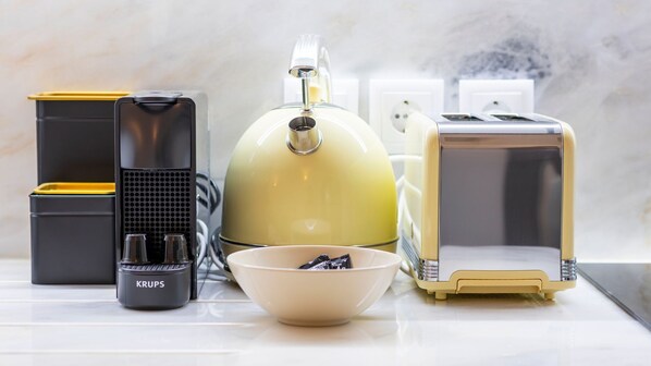 A kitchen with a kettle, toaster, and coffee maker.