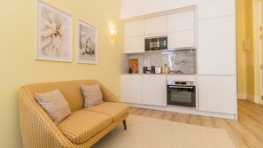 Un espace de vie compact comprenant un canapé, une kitchenette et un coin repas.