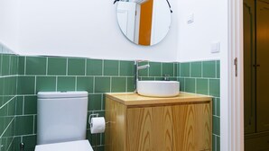 A bathroom with a toilet, a sink, and a mirror. - Urban House Marquês - C - by LovelyStay (Porto)