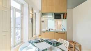 Una cocina compacta con microondas, pileta y muebles de madera.