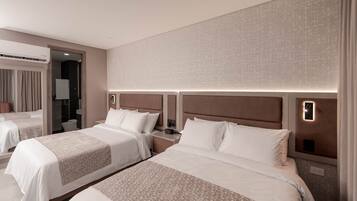 A hotel room with two beds, a large mirror, and a modern design.