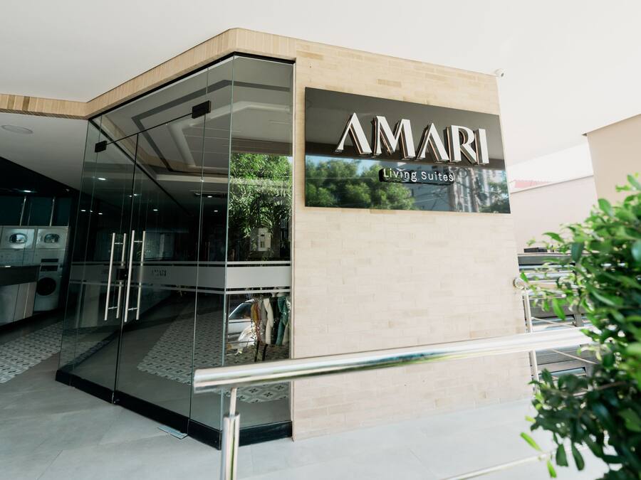 A modern building with a glass entrance and a sign that reads "AMARI Living Suites".