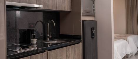 A modern kitchen with a built-in microwave, a coffee maker, and a sink.
