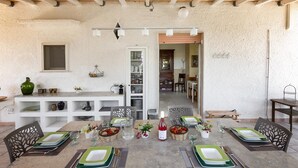 A dining area with a rustic ceiling, white walls, and a wooden table set for four. - 3547 Casa di Margherita by Barbarhouse (Manduria)