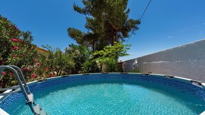 A clear blue swimming pool with a ladder, surrounded by lush greenery and a clear sky. - 3547 Casa di Margherita by Barbarhouse (Manduria)