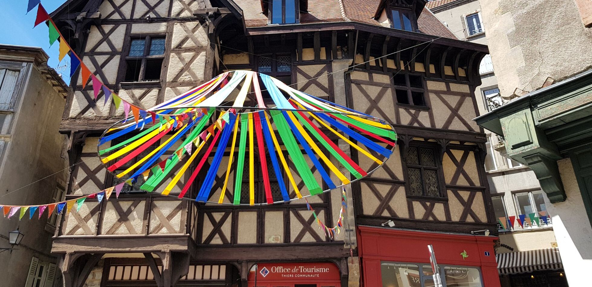 A traditional half-timbered building with a colorful striped awning.