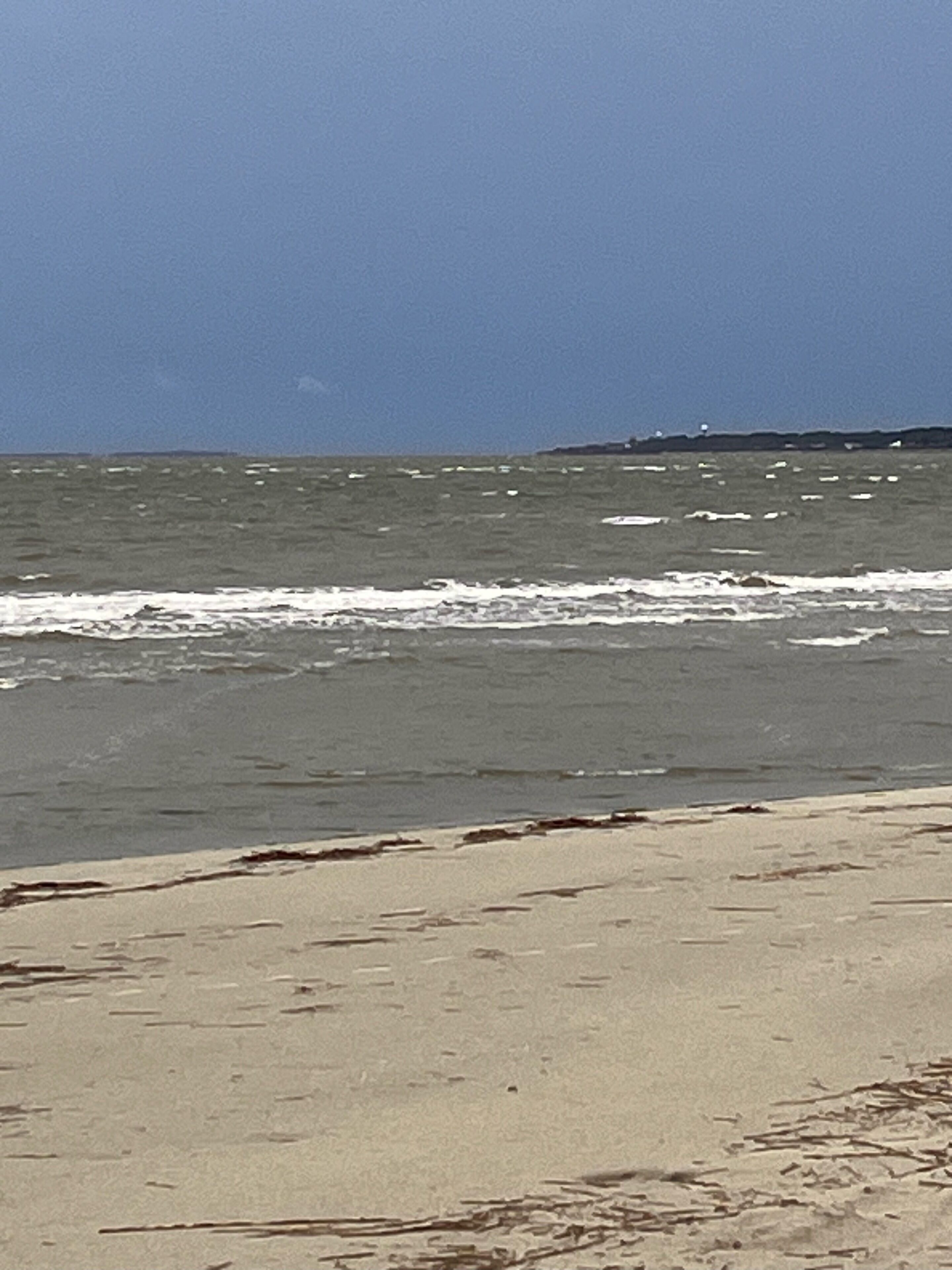 Une plage avec des vagues et un ciel dégagé.