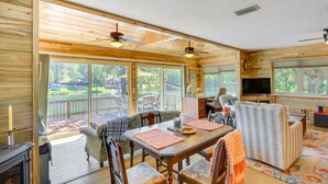 A spacious living room with a large wooden table, comfortable seating, and a television. - Kilgore Lakefront Home w/ Private Dock & Pier! (Kilgore)
