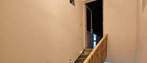 A staircase with wooden railings and a modern light fixture at the top.