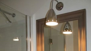 A bathroom with a large mirror, a sink, and a shower. - Goldoni77. (Milano)