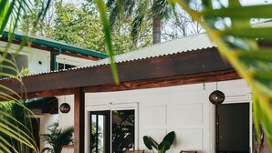 A swimming pool with lounge chairs and a covered patio area. - Dream Surf House Avellana (Tamarindo)