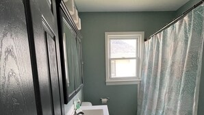A bathroom with a white sink, a toilet, and a window.