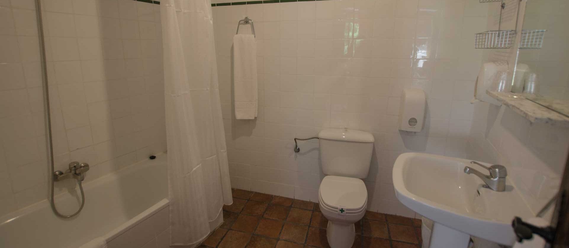 A bathroom with a bathtub, toilet, and sink.