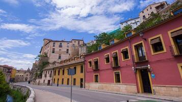 Una calle con edificios, incluyendo uno rojo con un letrero que dice "CASADA RUCEDA".